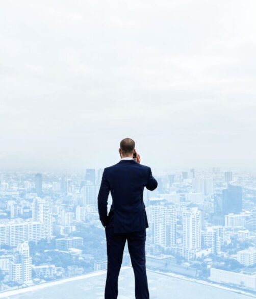 rear-view-businessman-talking-phone-top-building (1)